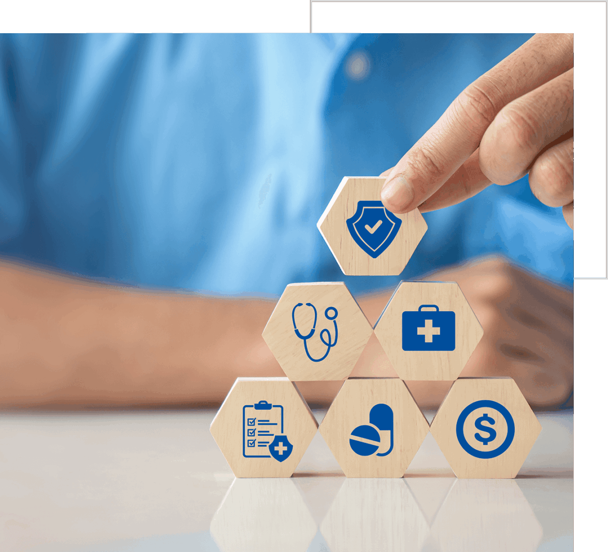 Hand stacking wooden blocks with various healthcare and insurance icons, symbolizing health coverage and financial protection.
