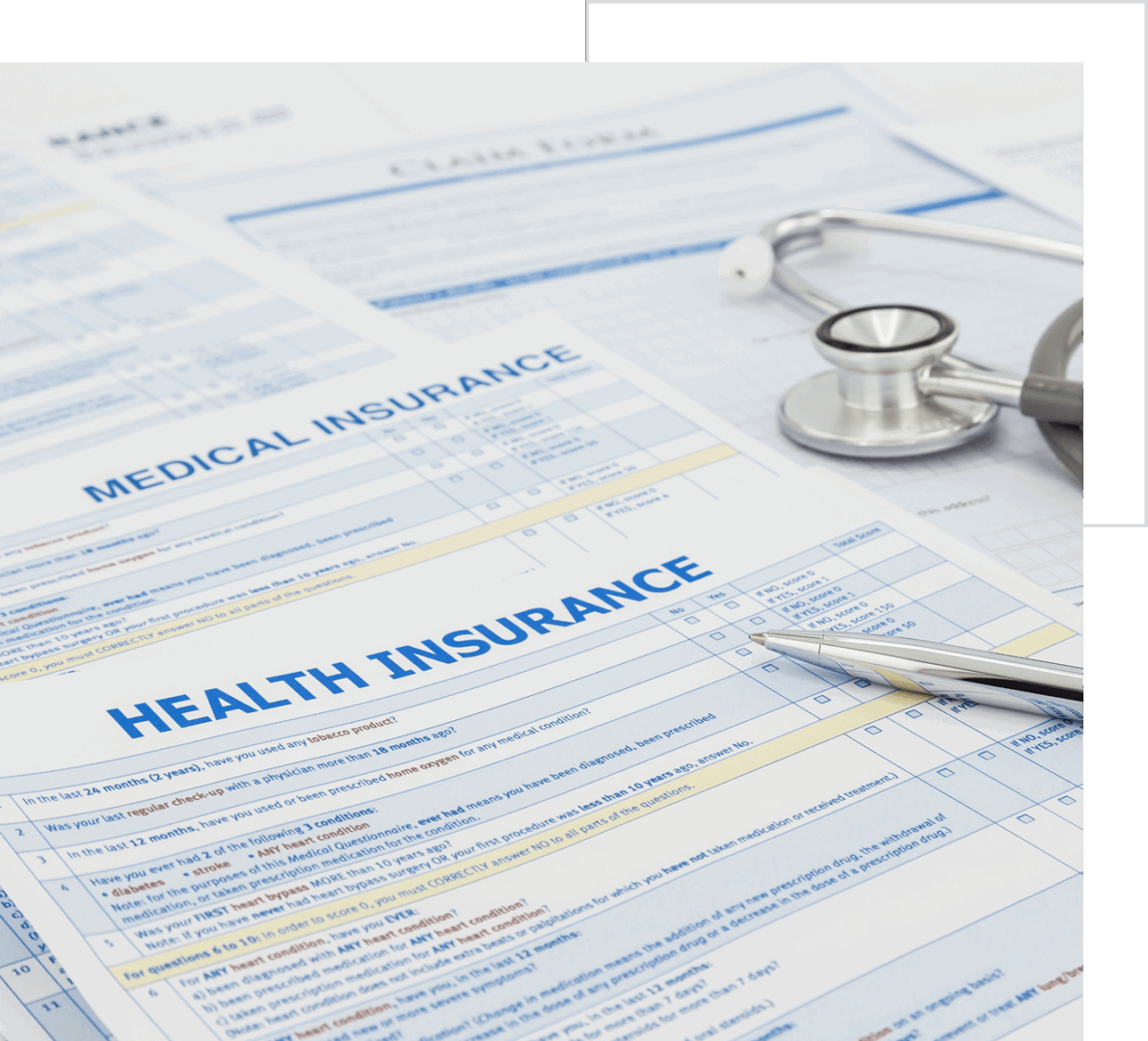 Close-up of health insurance forms with a pen and stethoscope on a white surface.
